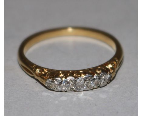 An early 20th century 18ct gold and five stone diamond half hoop ring, size M.