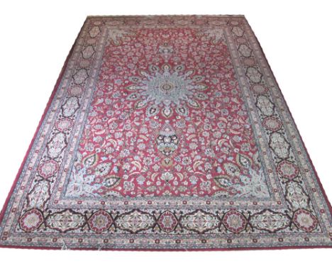 KASHAN CARPET, 400cm x 280cm, sky blue palmette medallion on a ruby field of scrolling vines within multiple bands and border