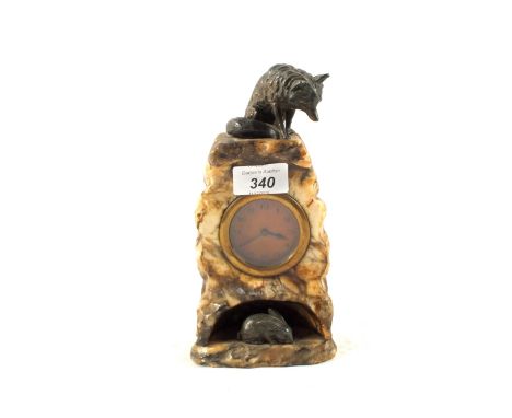 A carved marble cased mantel clock with silvered metal fox mount above a crouching hare