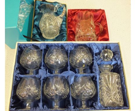 A boxed Bohemian crystal decanter set and two jugs