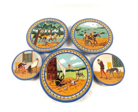 Five Spanish pottery plates depicting scenes from Don Quixote