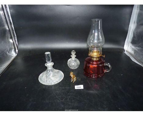 Two cut glass scents, brass dog match striker and cranberry oil lamp.