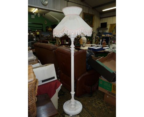 A Standard Lamp having a turned and fluted pillar and an elegant pleated white fabric shade with pink trimmings and tassels, 