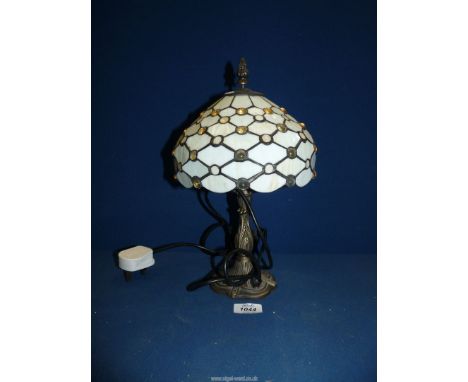 A Tiffany style table lamp with a cream jeweled glass shade, 13'' tall.