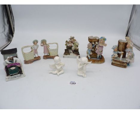 A quantity of china ornaments including two cherubs, boy and girl with baskets, plus Fairings - 'Last in bed to put out the l