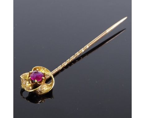 A Victorian unmarked gold ruby stick pin, with engraved foliate folded decoration, pin length 62.2mm, 2g 