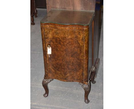 A bur walnut Queen Anne style serpentine pot cupboard, early 20th CenturyHaving a single serpentine door enclosing a single s