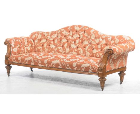 An attractive Victorian walnut setteeCovered in a leaf pattern teracotta fabric ,the arched button back above padded scroll a