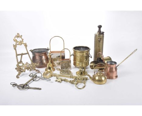 A collection of copper and brassware items 
To include a copper cauldron, easel back book stand, large oversize brass key orn