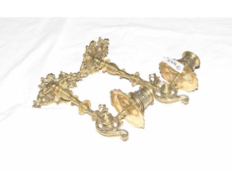 A pair of French gilt metal articulated wall sconceThe scalloped bracket with knoped and turned stem extending to a candle te