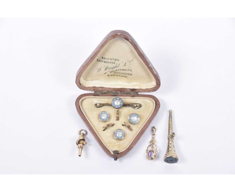 A mother of pearl and enamel cased button setWith a brooch, together with, a yellow metal knot watch key, a blood stone seal 