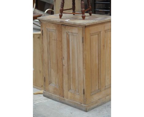 A Victorian pine two door cupboardHaving two invert moulded panelled cupboard doors enclosing a single shelf raised upon on a