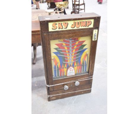 A Vintage wall mounted "Sky Jump Penny Slot Machine"The wooden case enclosing painted inter panel with five metalwork fitting