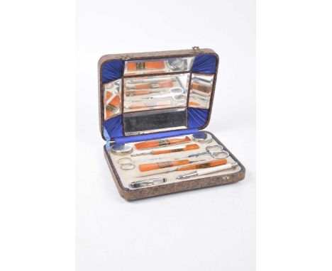 A vintage 1930's cased manicure setThe resin handled manicure set of orange and variegated design handles including ten indiv