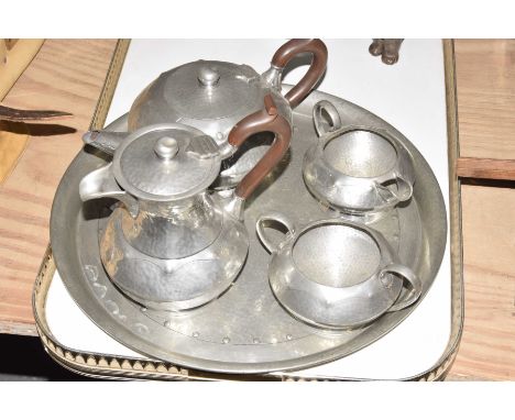 An Arts and Crafts hammered pewter tea service
To include tray, teapot, hot water jug, twin handled sugar bowl, milk jug, all