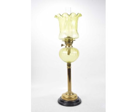 A late Victorian brass oil lamp The ebonised plinth base rising to a central brass column, with fluted glass oil receptacle a