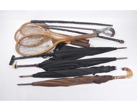 A quantity of vintage parasols, walking sticks and rackets
To include three various parasols, one with ivory handle, a shooti