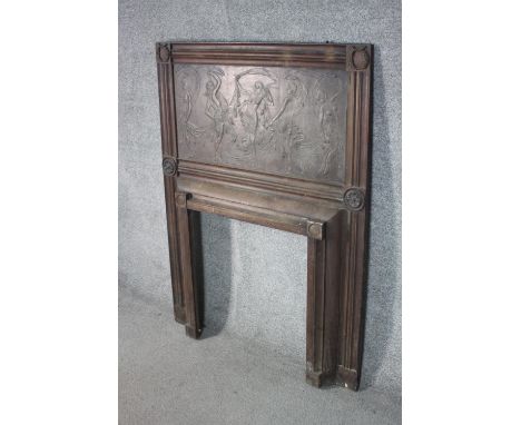An Art Nouveau carved and repousse wooden fireplace surround, the wooden panel depicting various dancing female nudes, the re