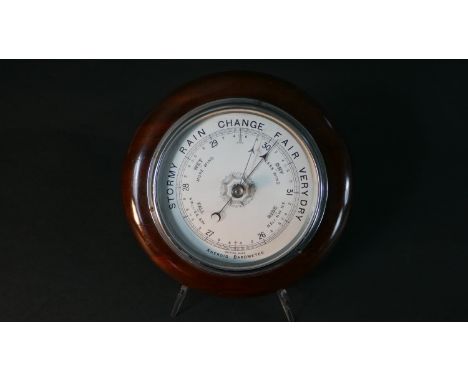 A circular mahogany aneroid barometer, the dial marked 'British Made'. Diam.25cm 