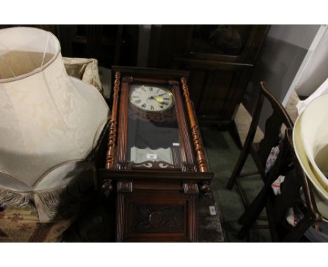 A late 19th century wall clock with mirrored interior and measuring 82 cm tall x 39 cm wide