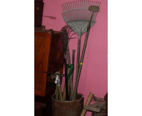 A small quantity of assorted garden tools to include rakes and pickaxes