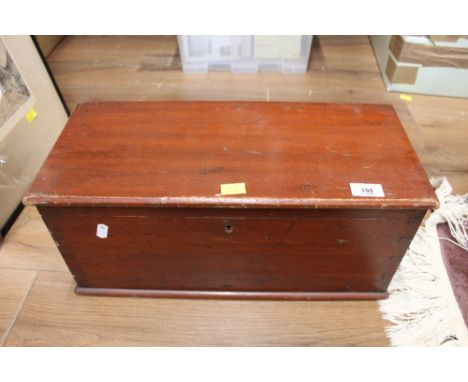 A stained pine box containing an accordion 