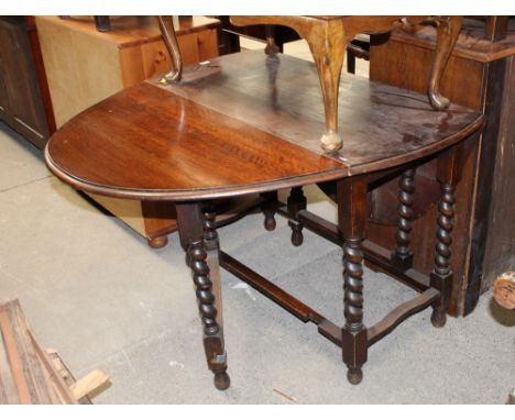 An oak drop leaf and gate leg table raised on turned legs 
