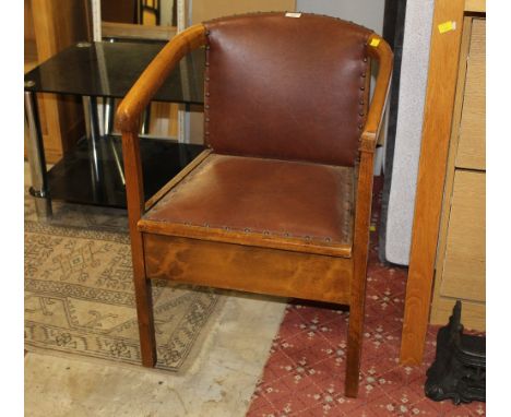 An early 20th century commode chair with lift up seat 