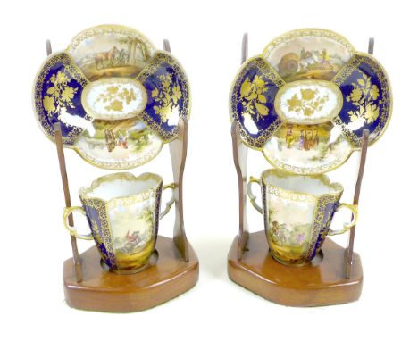 A pair of Dresden porcelain cabinet twin handled cups and quatrefoil saucers, late 19th century, decorated with dark blue and