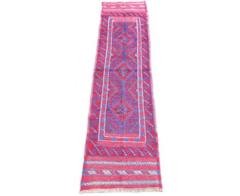 A Meshwani runner, red ground with three and a quarter diamond shapes to central panel, with multiple borders and flat weave 