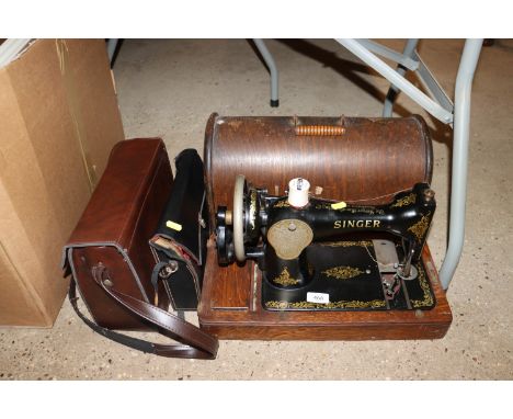 An oak cased Singer sewing machine and two vintage Eumig cine cameras