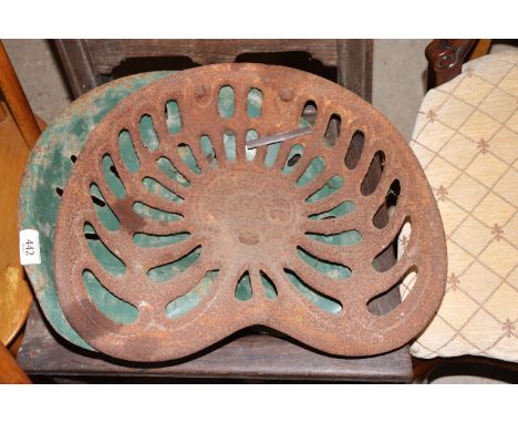 Two vintage cast iron tractor seats