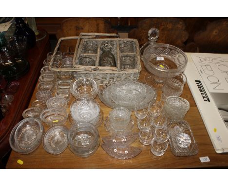 A quantity of various glass salt cellars; a cut glass pedestal bowl; a heavy glass scent bottle; a carafe set in wicker holde