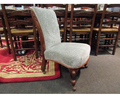 An early Victorian walnut nursery open armchair with carved acanthus leaf scroll back rest over carved cabriole legs and cera