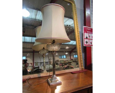 A silver plated column form table lamp with glass reservoir design and shade