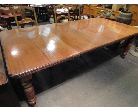 A Circa 1900 mahogany extending dining table with two extra leaves and winding handle, the canted corner top over ring turned