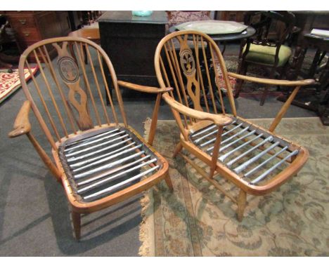 A pair of Ercol low lounge armchairs with Prince of Wales feathers to back