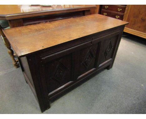 A 17th Century oak coffer, the rising lid over a carved three panel front on stile feet, with lidded internal candle box, 113