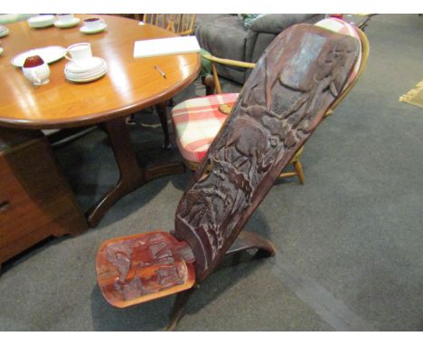An African hardwood tree trunk chair carved with various African animals