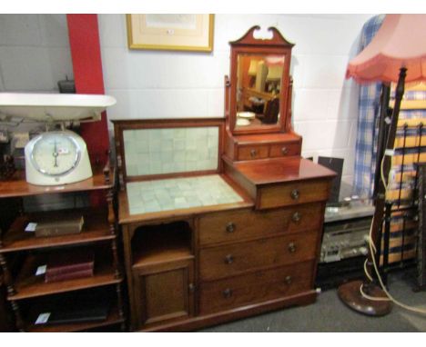 In the manner of "Maple &amp; Co" a late Victorian walnut combination washstand dressing chest, the tilt mirror over six draw