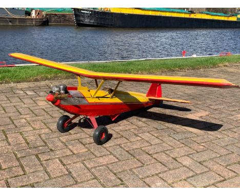 A Radio Controlled model plane, with a Super Tigre 60 engine, removable cockpit cover opens to reveal servos, with a figure o