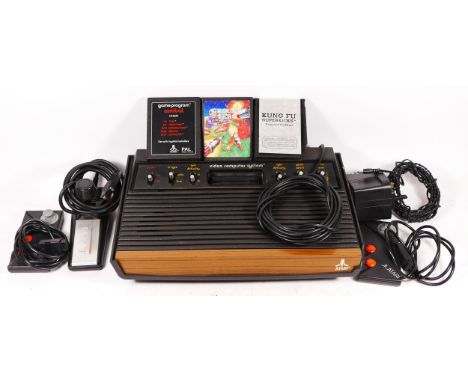 A Atari 2600 console (serial No 813633), with power and AV cables, a two button joystick and two Atari two button controllers