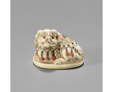 A SHIBAYAMA-INLAID IVORY NETSUKE OF A CAPARISONED SHISHIUnsigned Japan, Tokyo, late 19th century, Meiji period (1868-1912)Wel