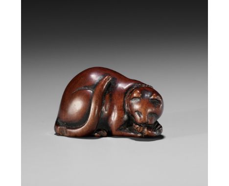 AN EARLY WOOD NETSUKE OF A CAT DEVOURING A FISHUnsignedJapan, 18th century, Edo period (1615-1868)A beautifully rounded and c