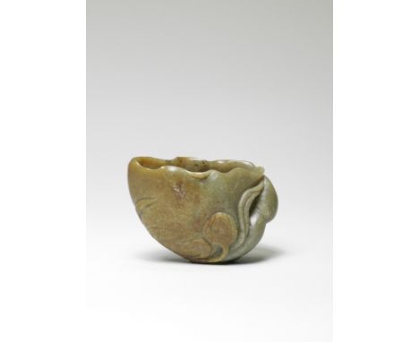 A GREEN AND RUSSET JADE 'LOTUS-LEAF' CUP17th century Finely carved as a naturalistic furled lotus leaf, vividly curling outwa