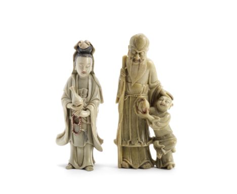 TWO SOAPSTONE CARVINGS17th/18th centuryComprising a standing figure of Guanyin, the Goddess of Mercy and Compassion, with alm