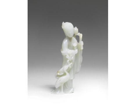 A VERY PALE GREEN JADE FIGURE OF HE XIANGU17th/18th centuryThe Daoist Immortal well carved standing beside a crane grasping a