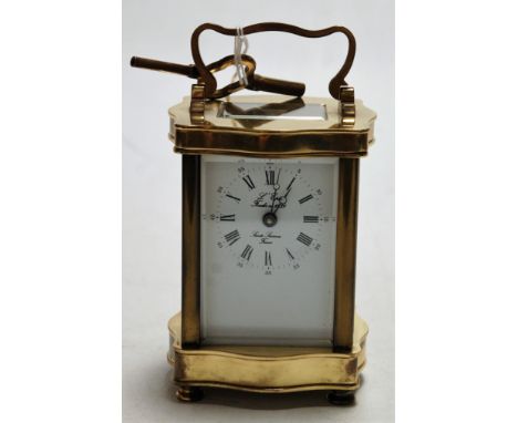 A French lacquered brass cased carriage clock, of serpentine shape, the enamelled dial with inner Roman numerals and outer Ar