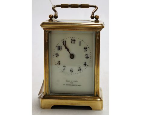 An early 20th century lacquered brass cased carriage clock, the enamelled dial with Arabic numerals, signed Made in Paris for