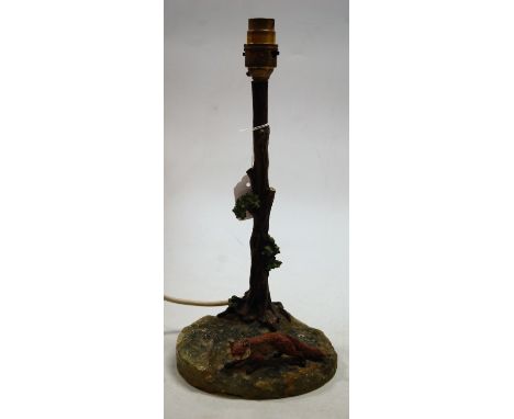 A painted metal and onyx table lamp, modelled as a fox against a tree stump, 30cm